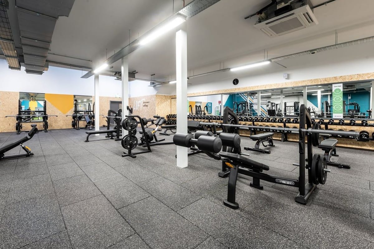 PureGym Inverness Inshes Retail Park: Weight racks, benches, dumbbells, rubberised flooring in a gym setting.