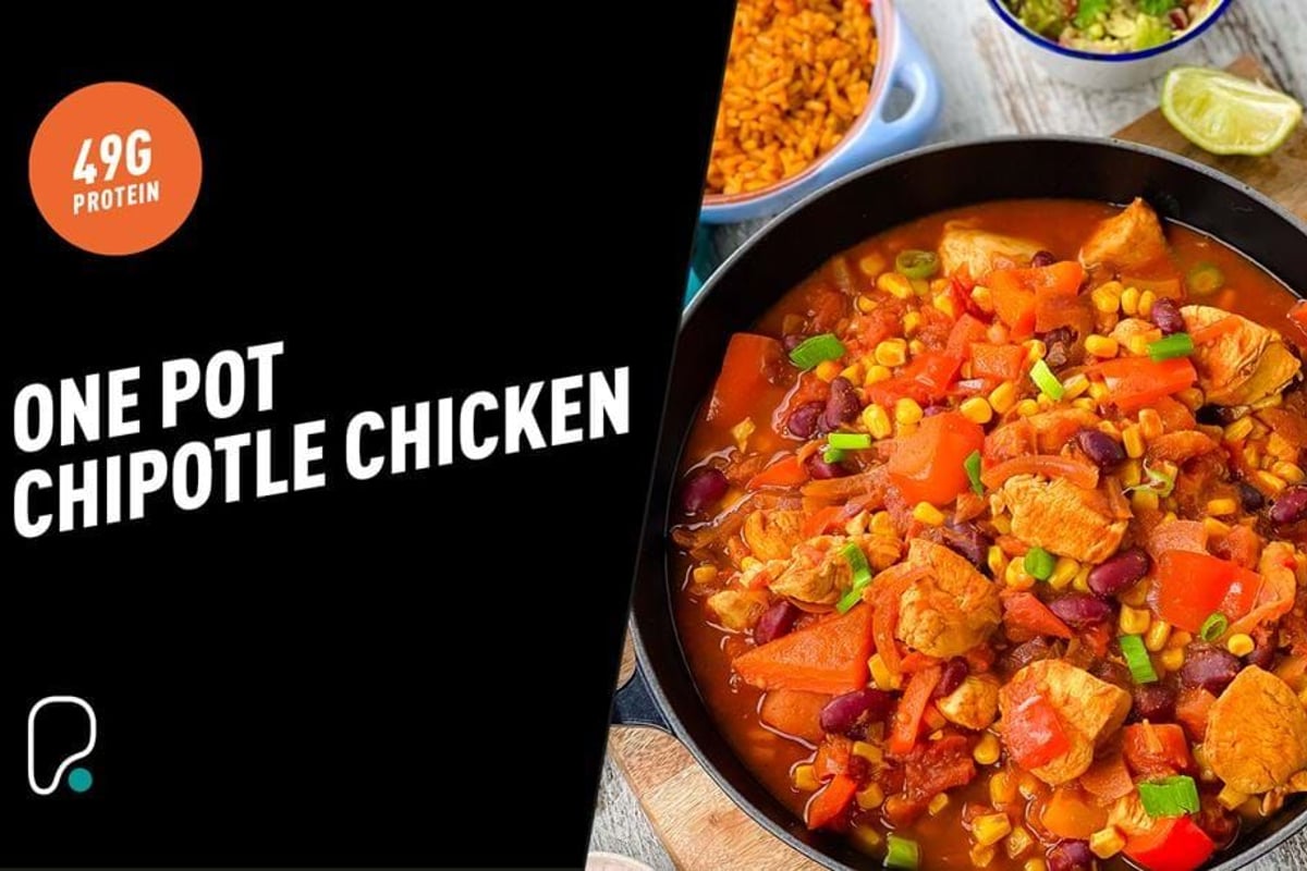 One pot chipotle chicken stew with corn, beans, and red peppers in a black pan