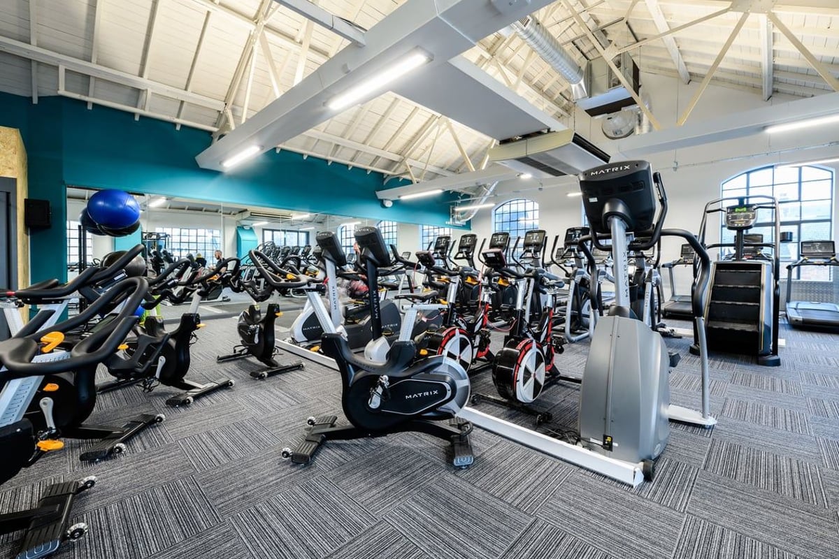 PureGym London Bow Wharf: Rows of stationary bikes, treadmills, elliptical trainers in a bright gym interior.