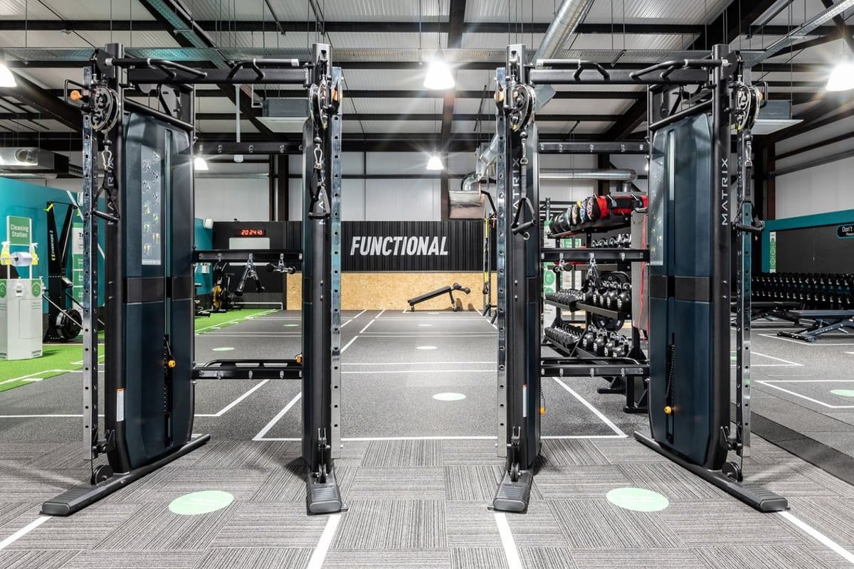 PureGym Kirkcaldy: Functional training area with hanging rigs, weightlifting platforms, free weights, and rubberized floors.