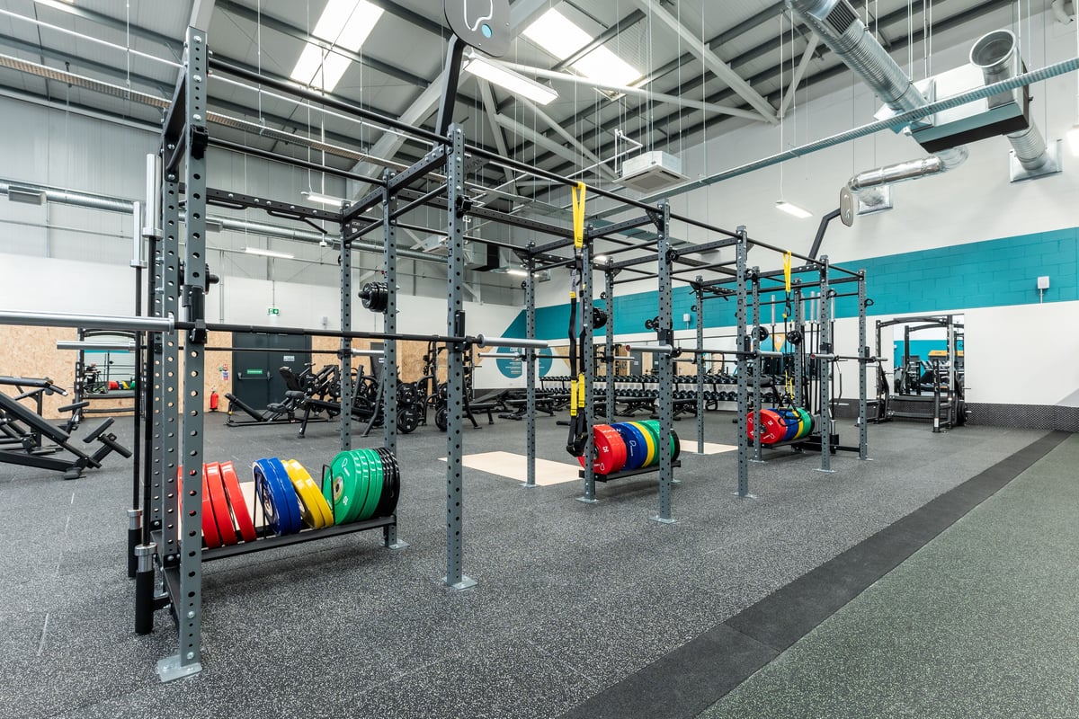 PureGym Port Talbot: Rigs, weight plates in vibrant colours, rubberized floors in an open gym space.