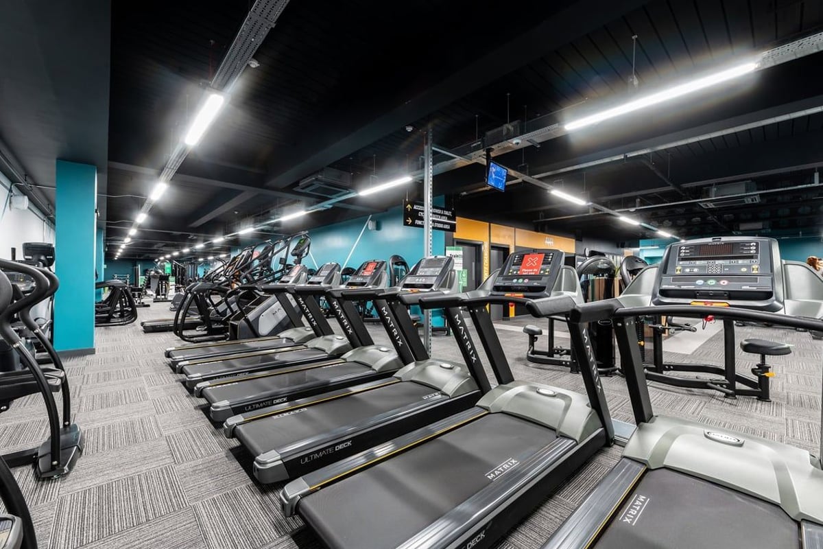 PureGym London Bank: Rows of treadmills, cross-trainers, bikes in a brightly lit gym with teal accents.
