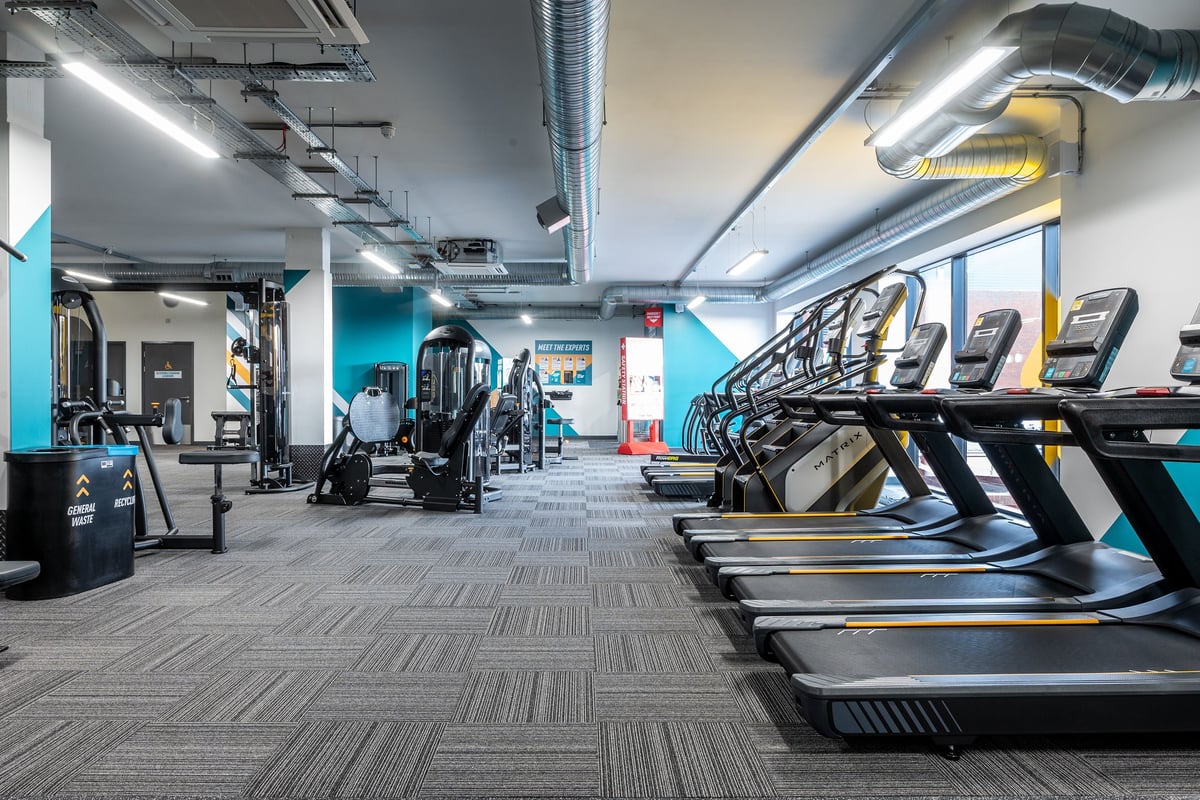 PureGym London Swanley: Rows of treadmills, resistance machines, weight benches in an industrial-style gym interior.