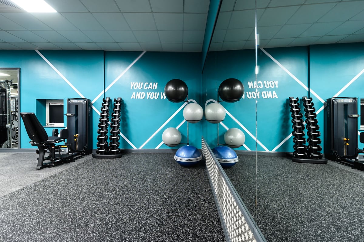 PureGym Waterlooville: Weight balls, resistance machines, motivational wall graphics, rubberized flooring in gym studio.