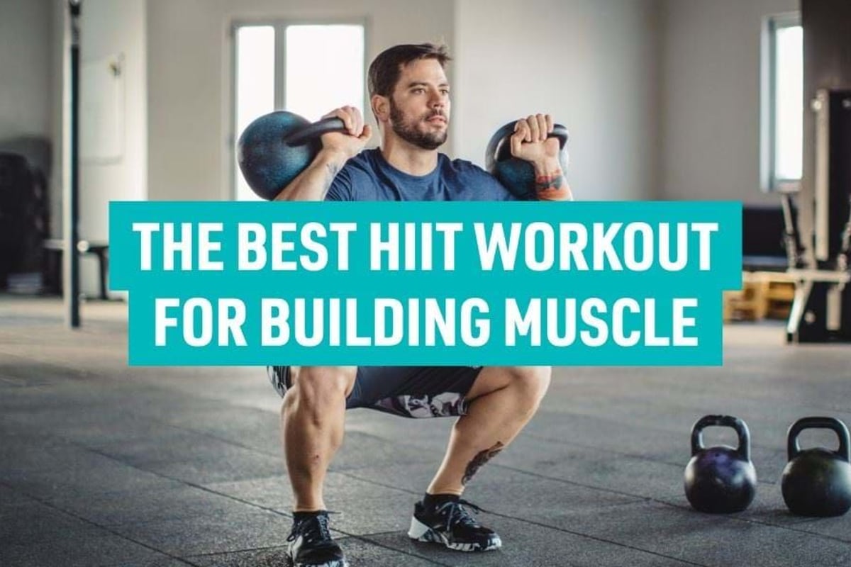 Man squatting with two kettlebells in a gym with two more kettlebells on the floor.