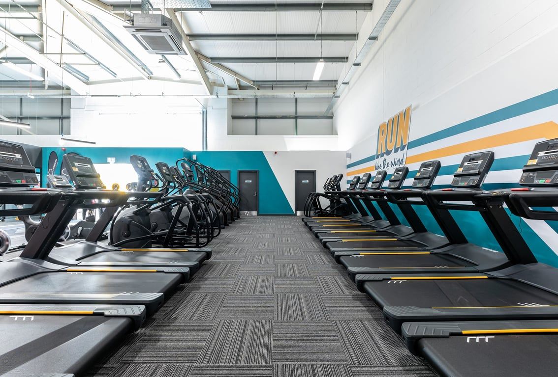 PureGym Great Yarmouth: Rows of treadmills and other cardiovascular exercise machines in a bright gym interior.