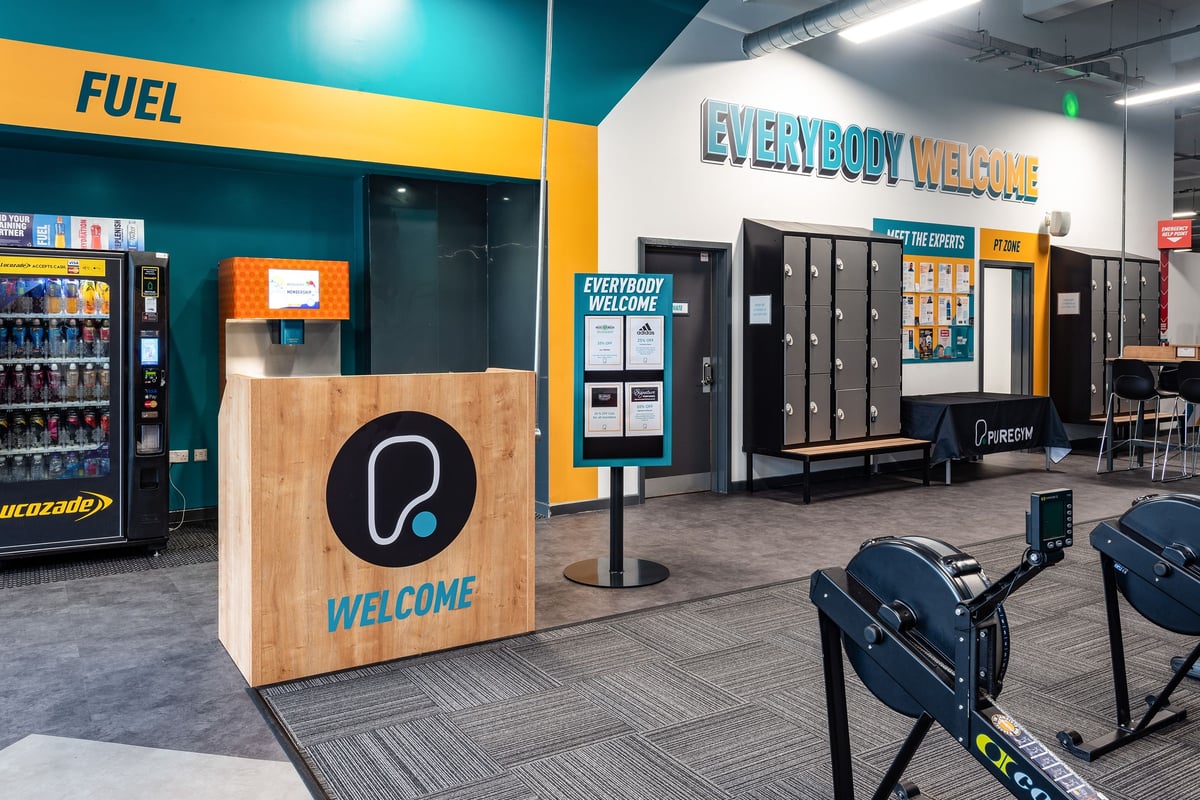 PureGym Leicester St Georges Way: Fuel vending machines, lockers, seating area, and signage "Everybody Welcome."