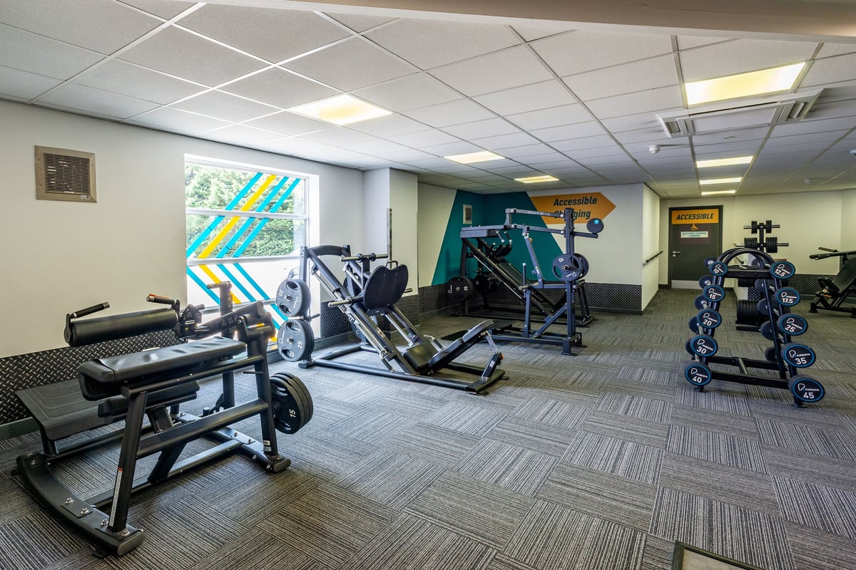 PureGym Northwich: Resistance machines, benches, free weights, and mirrored walls in a gym studio.