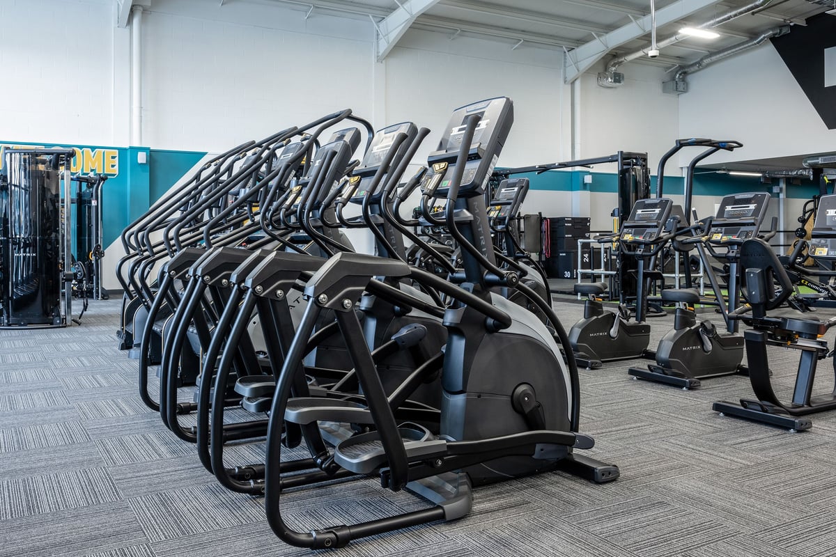 PureGym Falkirk: Rows of elliptical machines and exercise bikes in a gym setting.