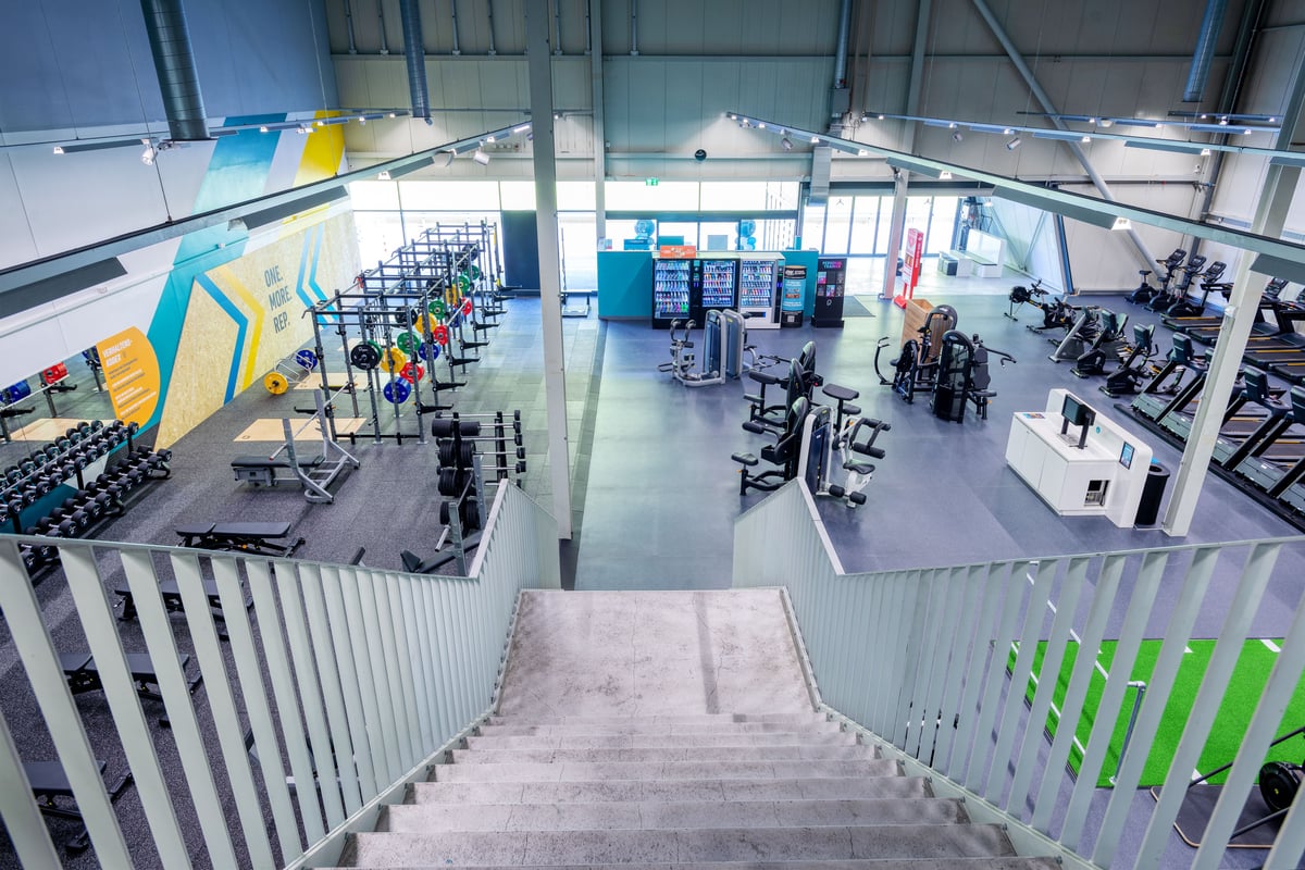 Gym Oftringen overview from staircase with weights, machines and cardio area