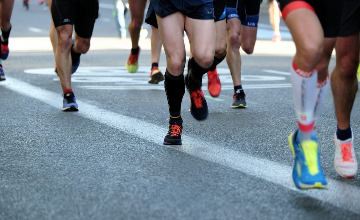 Group of runners in colourful trainers running on a road during a marathon race