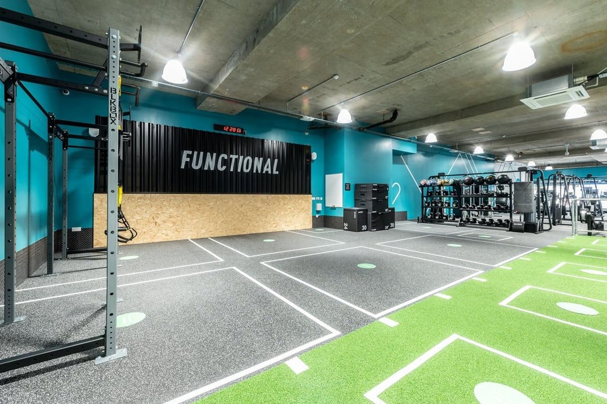 PureGym London Leytonstone: Indoor functional training area with turf, rig, weights, rubberized flooring and teal accents.
