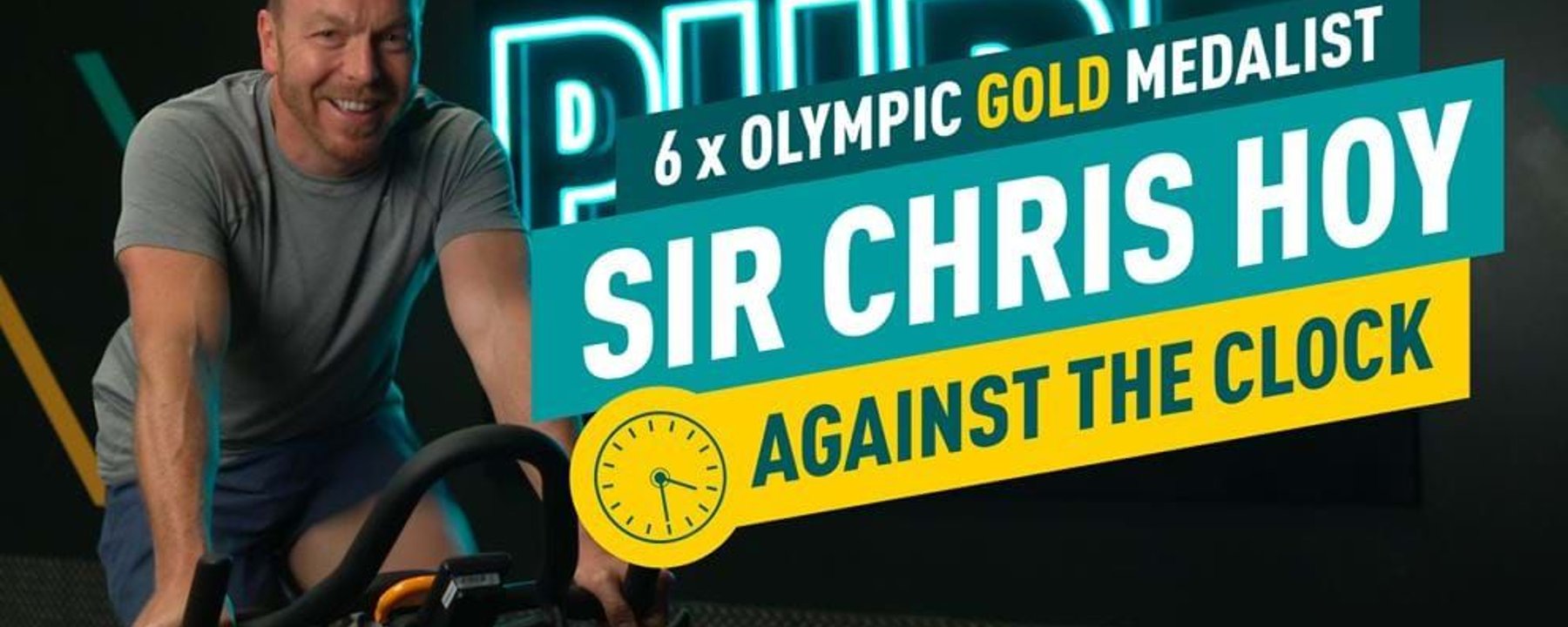 Man in grey t-shirt cycling indoors with text about Sir Chris Hoy and Olympic gold medals.