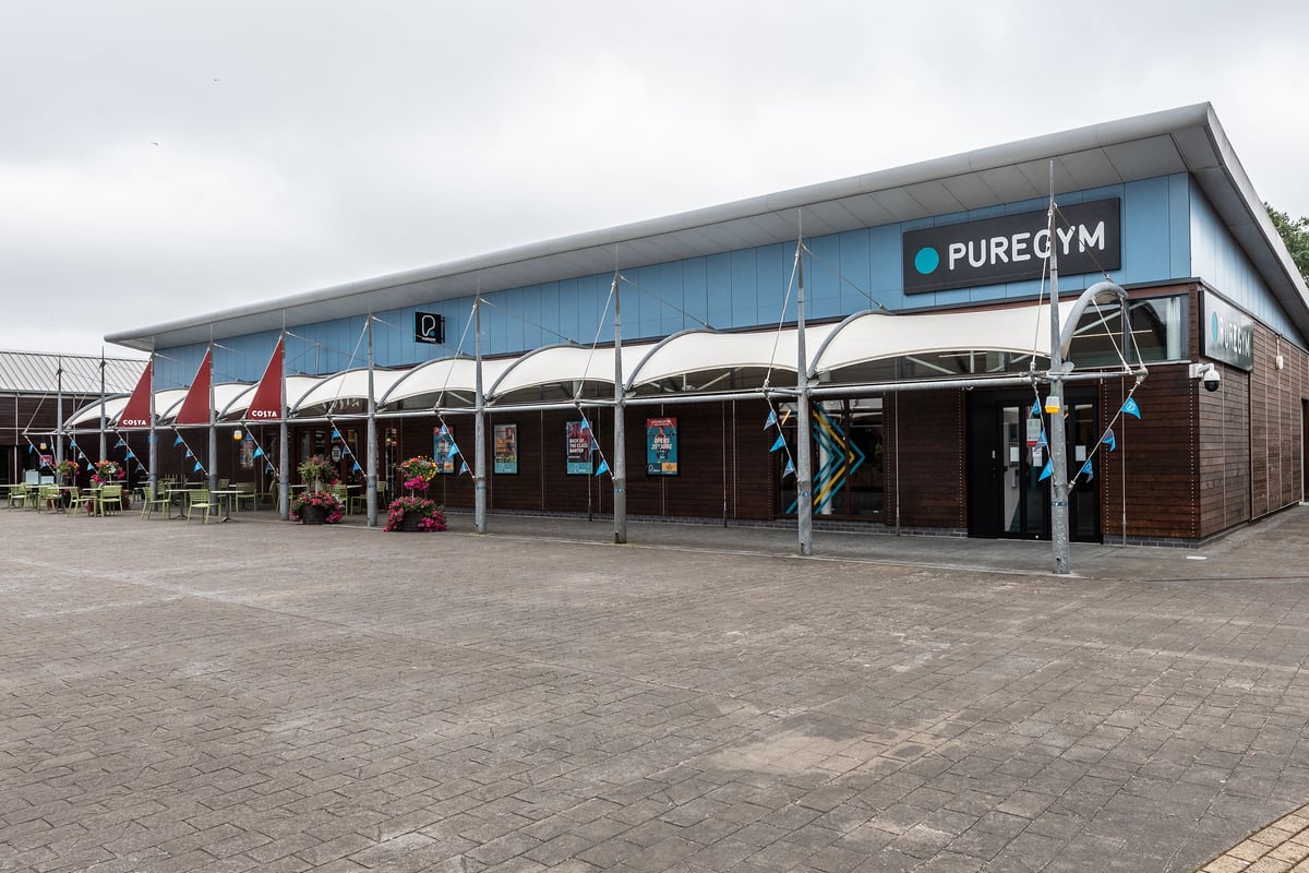 PureGym Bideford: Exterior of gym with outdoor seating area and branded signage.