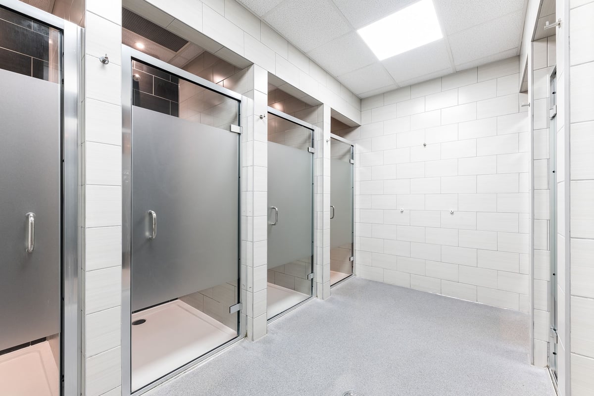 PureGym Reading Basingstoke Road: Shower cubicles, tiled walls, doors with frosted glass panels.