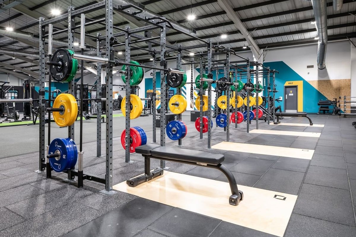 PureGym Leeds Bramley: Power racks, weighted plates in multiple colours, benches, and rubberised flooring.
