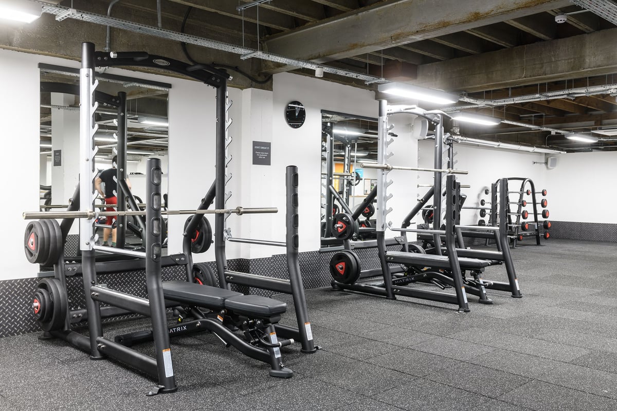 PureGym Brighton London Road: Squat racks, weight plates, pull-up rigs, rubberized flooring in a basement gym.