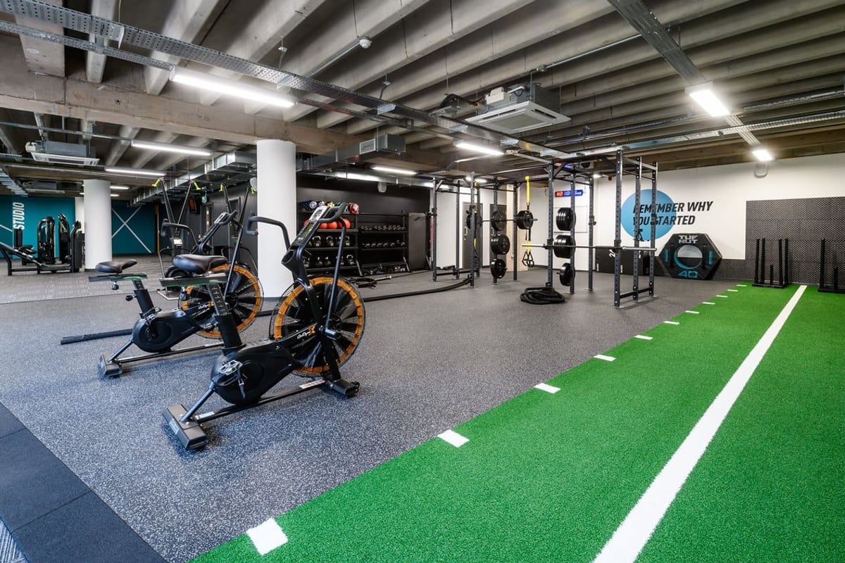 PureGym Birmingham Arcadian Centre: Gym studio with exercise bikes, resistance machines, turf area, and rubberized flooring.