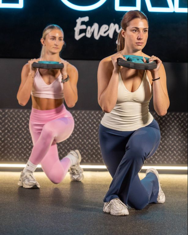 Two PureGym members crouching with free weights