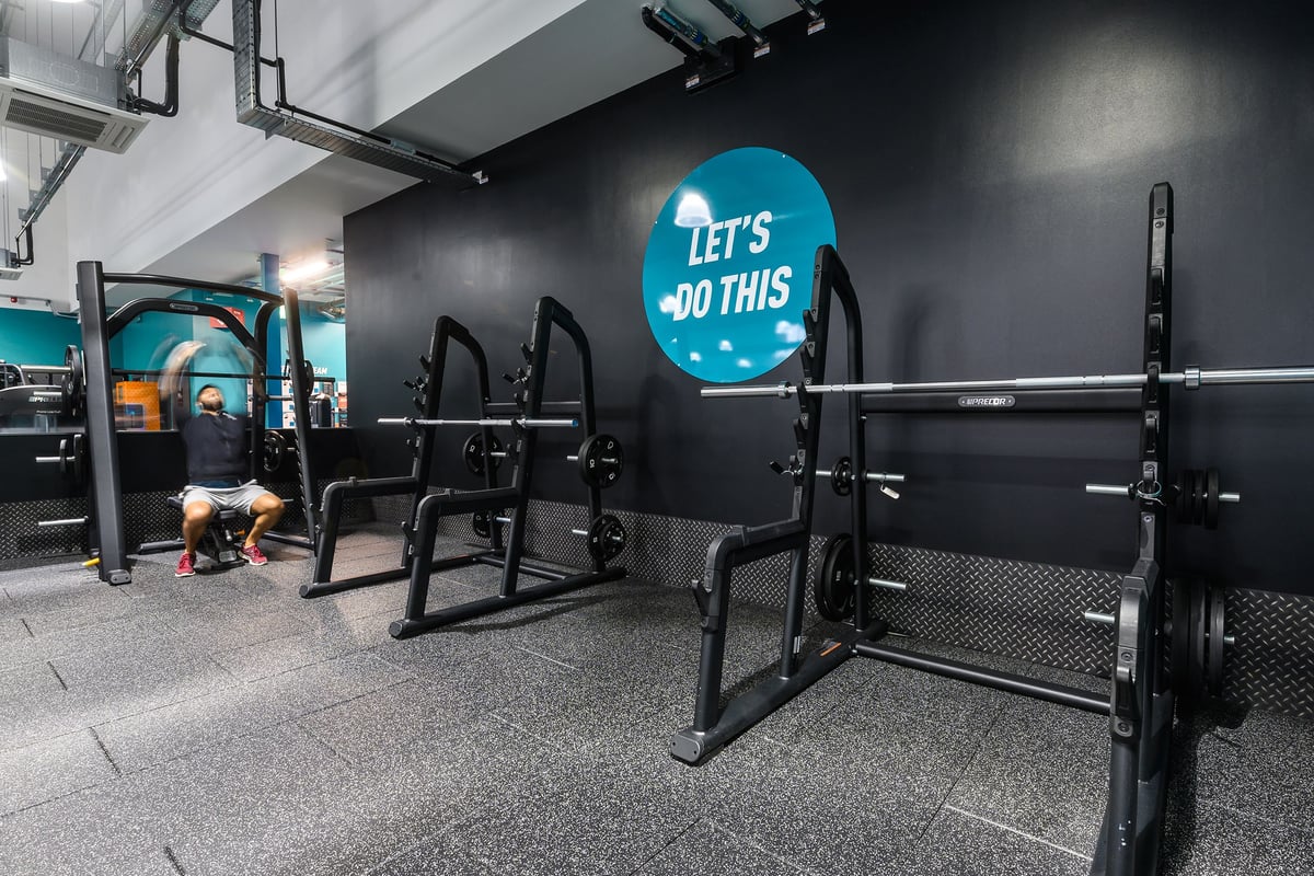 PureGym Bromsgrove Retail Park: Bench press racks, squat stands, rubberized floors, and motivational wall signage.