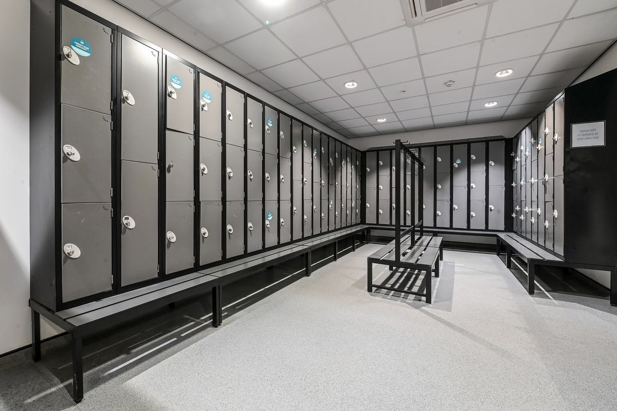 PureGym Canterbury Sturry Road: Rows of lockers, benches lining the walls in a functional changing room space.