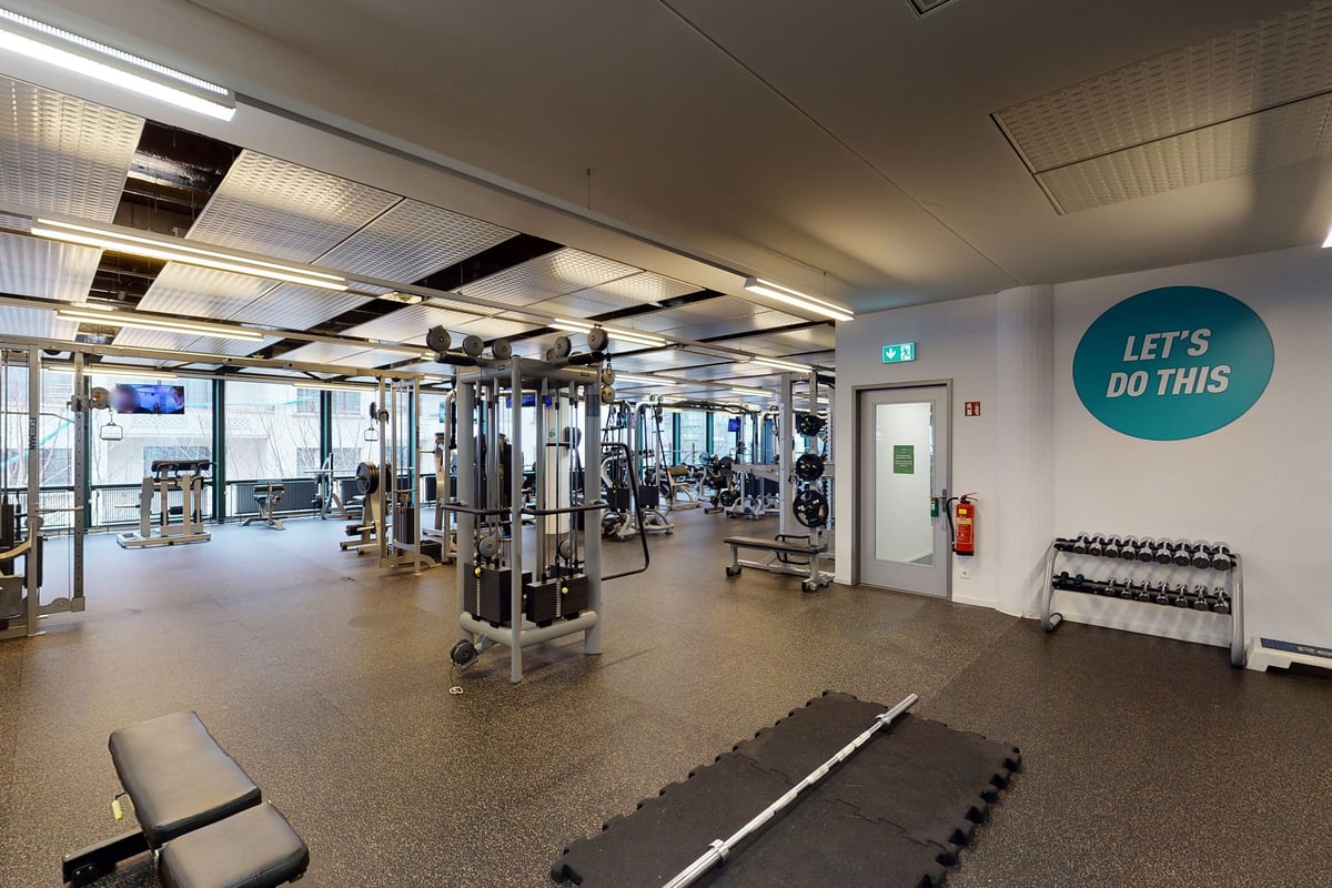 PureGym Biel Bienne: Appareils de musculation, haltères, bancs, miroirs et panneaux de motivation.