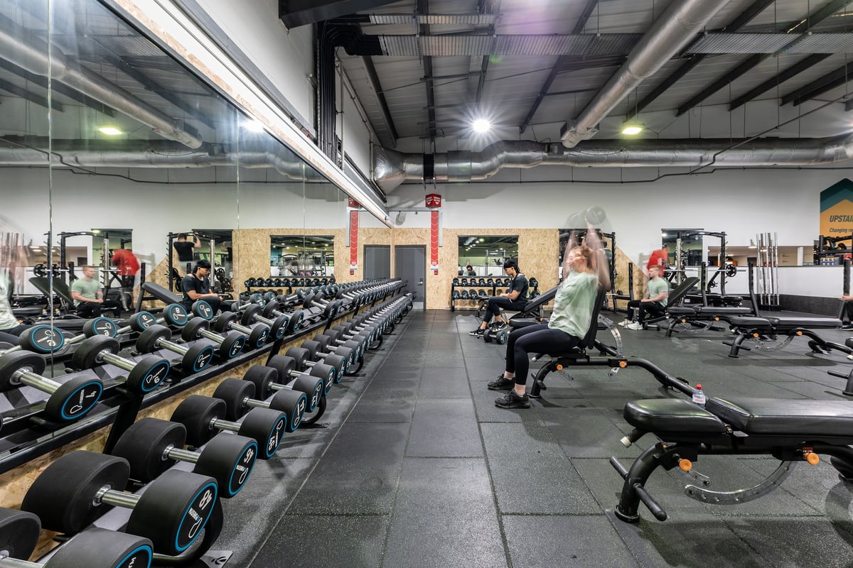 PureGym Lincoln St Marks Centre: Rows of rowing machines, exercise bikes, free weights, and mirrors in a fitness center.