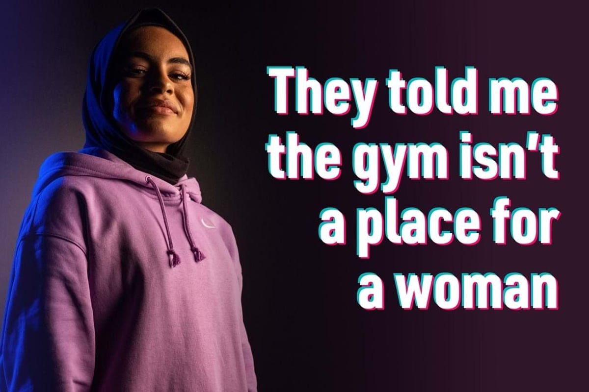Woman in hijab and pink hoodie with text about gym not being for women