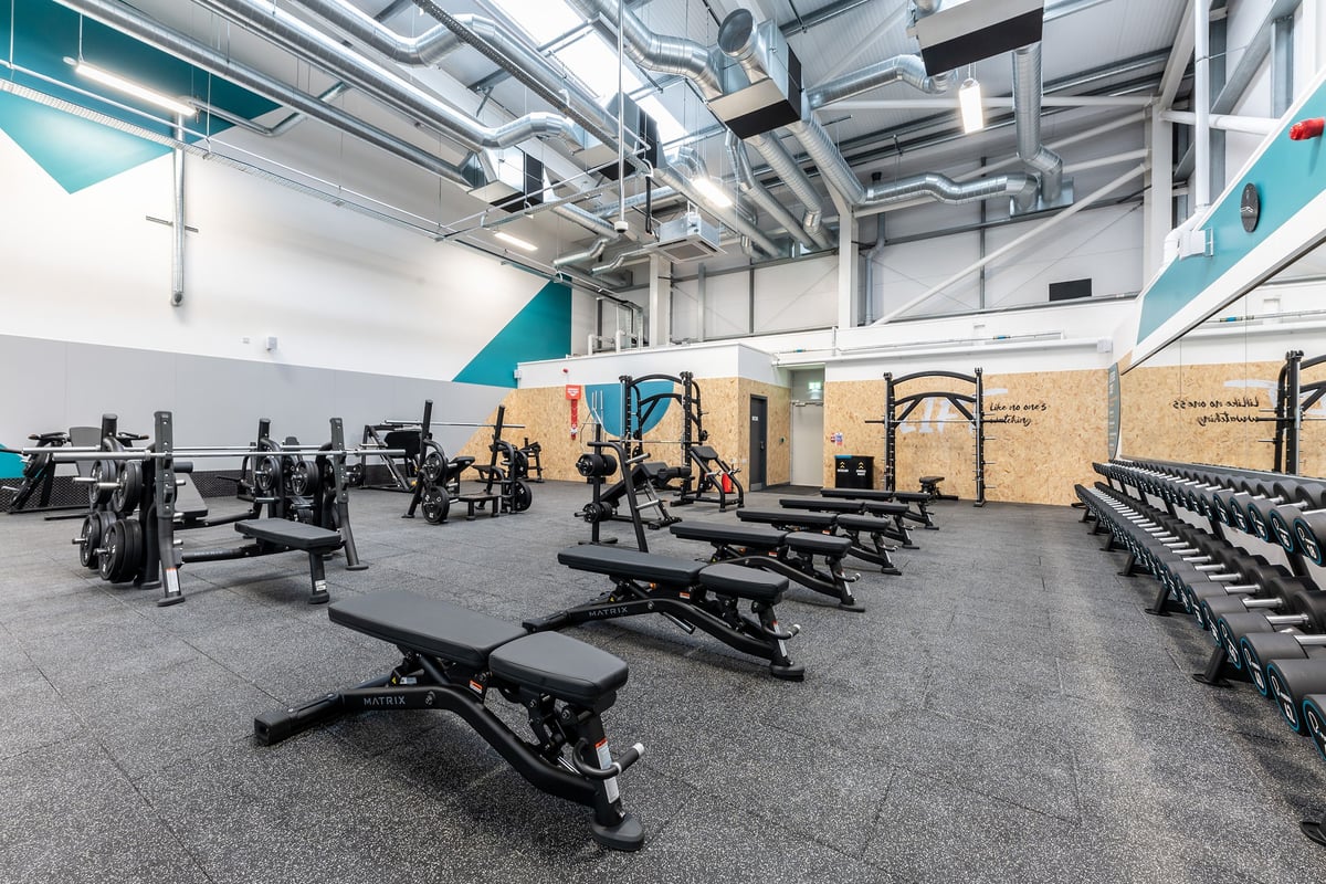 PureGym Blyth: Weight benches, squat racks, dumbbells, rubberized flooring in a modern gym interior.