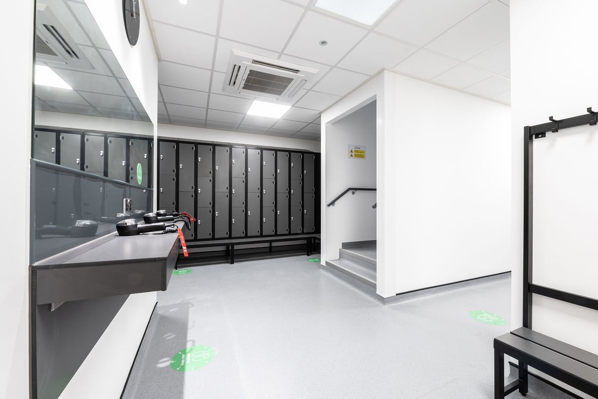 PureGym Puregym Crayford: Lockers, sinks, benches, and rubberized flooring inside a changing room.