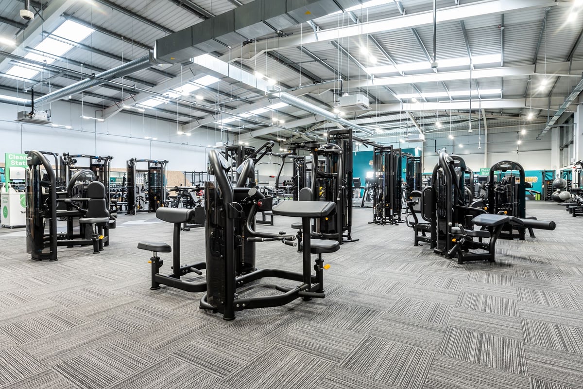 PureGym Newbury: Rows of resistance machines, benches, and weight racks on rubberized flooring.