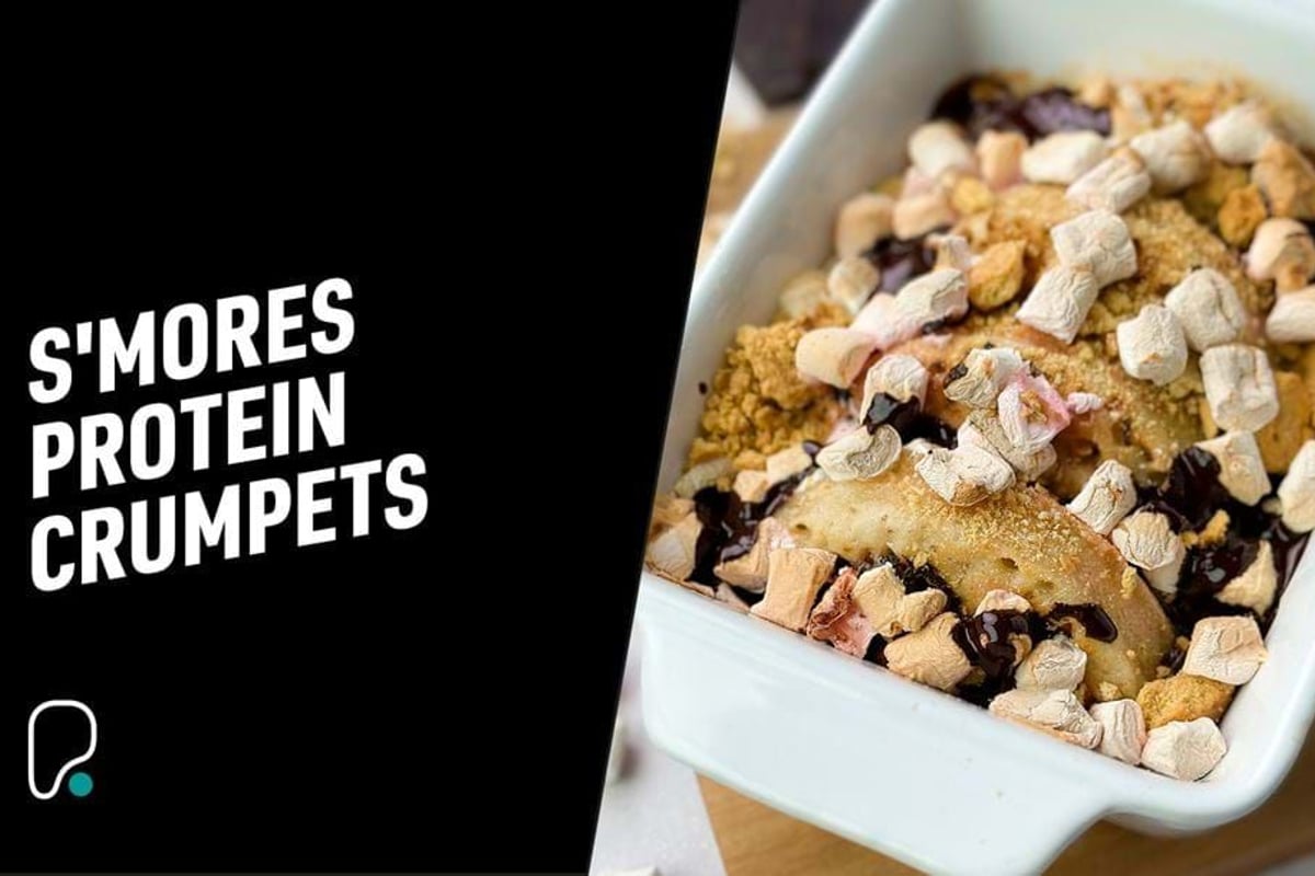 Baked crumpets topped with mini marshmallows, chocolate sauce, and crumbs in a white dish