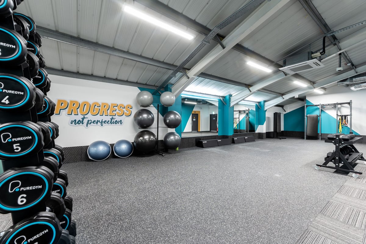 PureGym Bath Victoria Park: Rows of kettlebells, medicine balls, wall-mounted pads, and rubberized flooring.