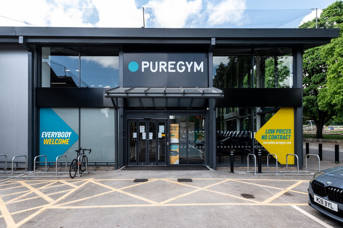 PureGym Bath Victoria Park: Exterior view of a gym with glass frontage, signage and a parked bicycle.