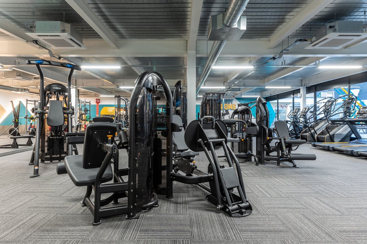 PureGym Droitwich Spa: Weight machines, resistance equipment, mirrored walls, and rubberised flooring in a gym setting.