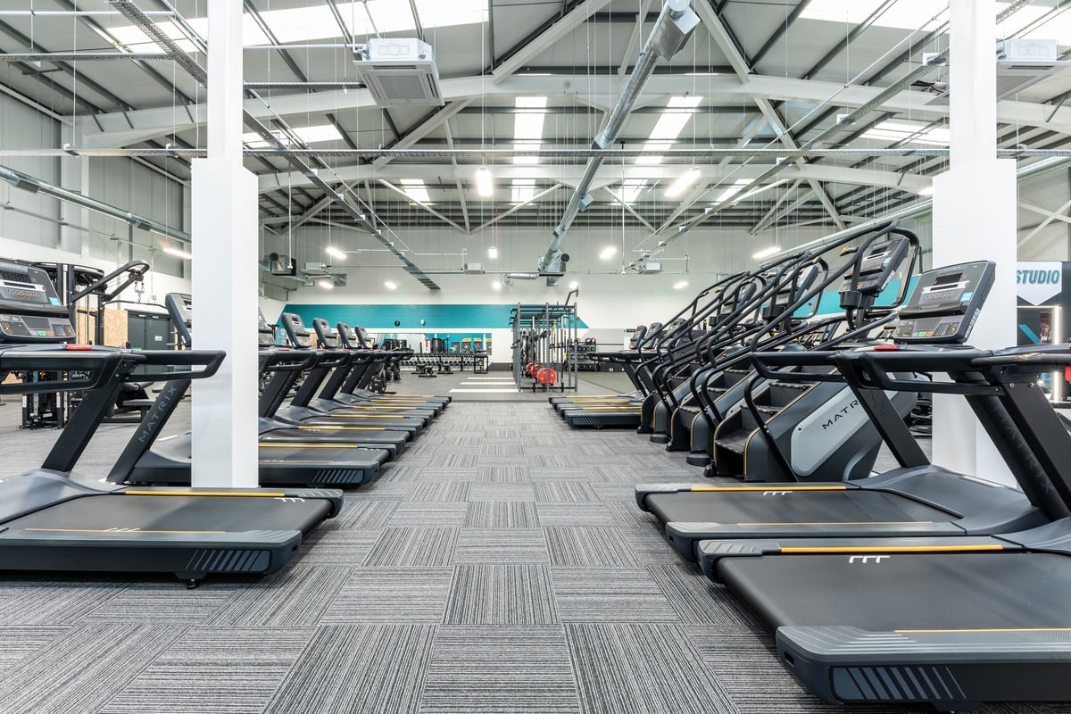 PureGym Port Talbot: Rows of treadmills, sleek designs with vibrant graphics on the displays.
