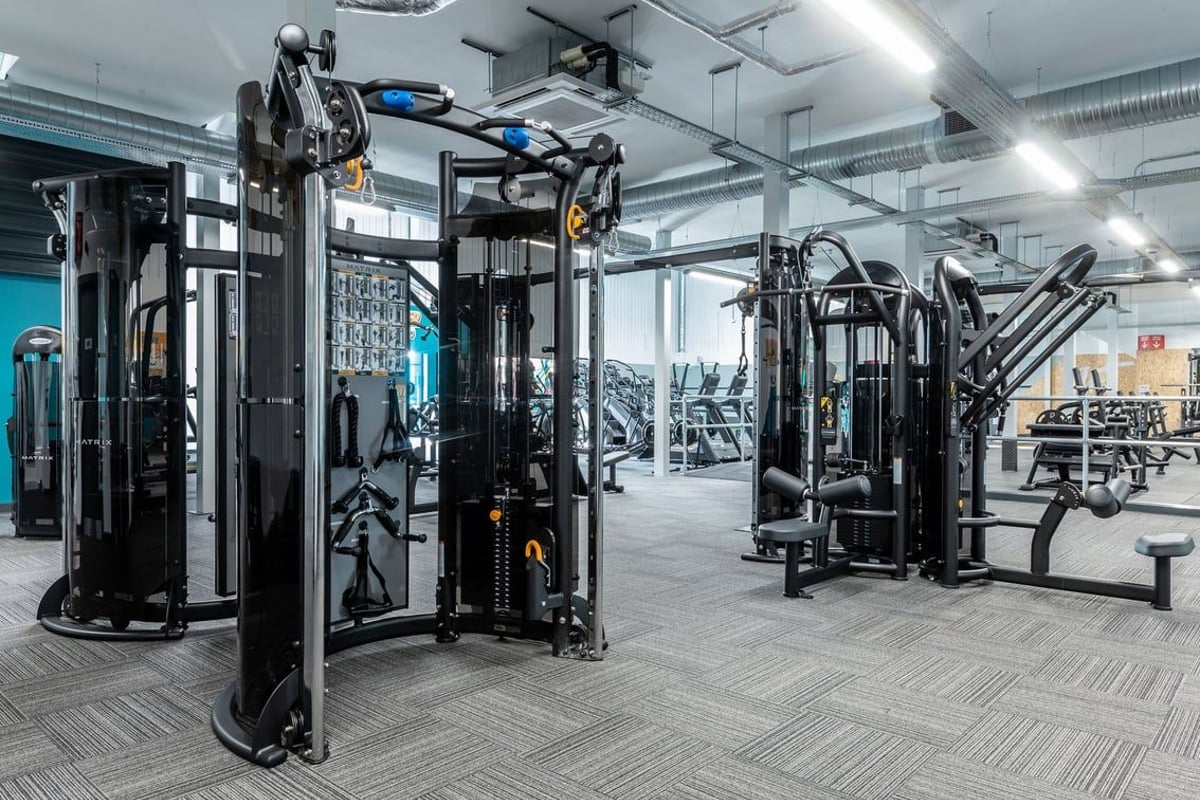PureGym Grantham Discovery Retail Park: Gym with weight machines, cable crossovers, benches, and rubberized flooring.