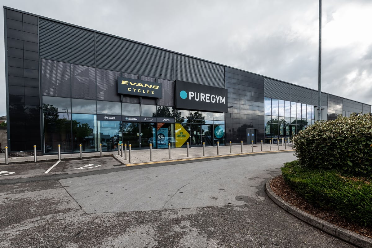 PureGym Manchester Cheetham Hill Retail Park: Modern gym building exterior with large glass windows and signage.