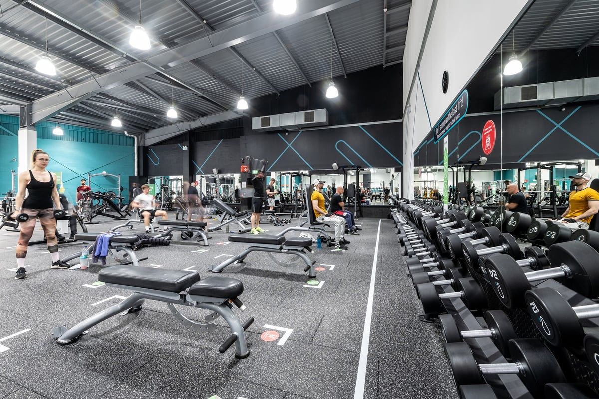 PureGym Warrington Central: Gym interior with weight machines, free weights, benches, and rubberized flooring visible.