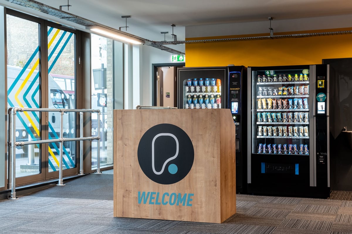 PureGym London Seven Sisters: Vending machines, reception counter, and glass exterior with geometric design elements.