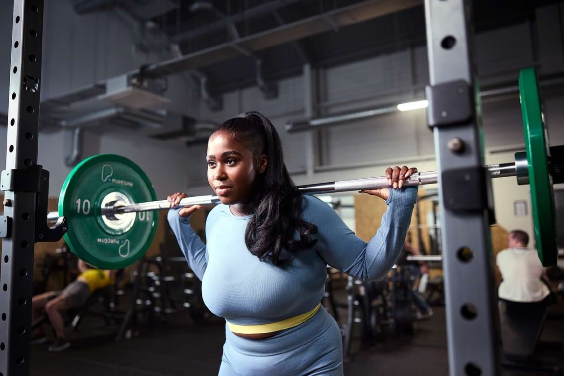 PureGym member lifting a barbell