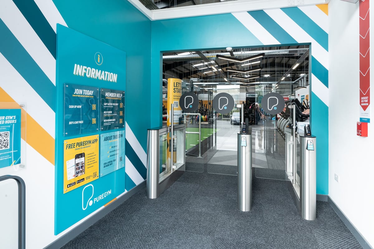 PureGym Dover: Turnstiles, information signage, and a glimpse of gym equipment through glass doors.