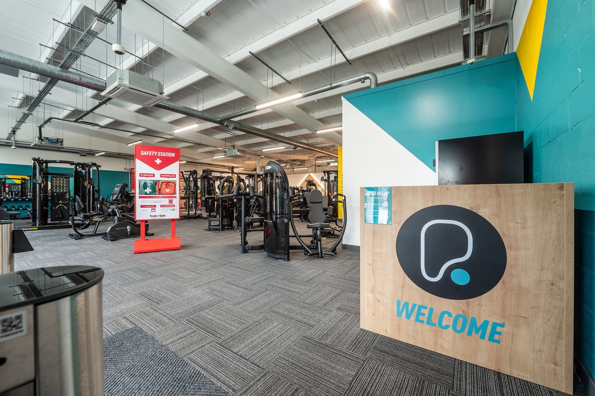 PureGym Bideford: Gym with weight machines, free weights, and strength training equipment in an industrial-style space.