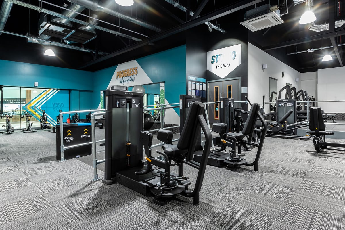 PureGym Bracknell: Strength training area with cable machines, weightlifting racks, benches, rubberized floors.