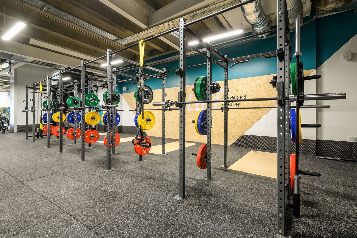 PureGym London Wimbledon: Power racks, colourful weight plates, and rubberized flooring in a fitness studio space.