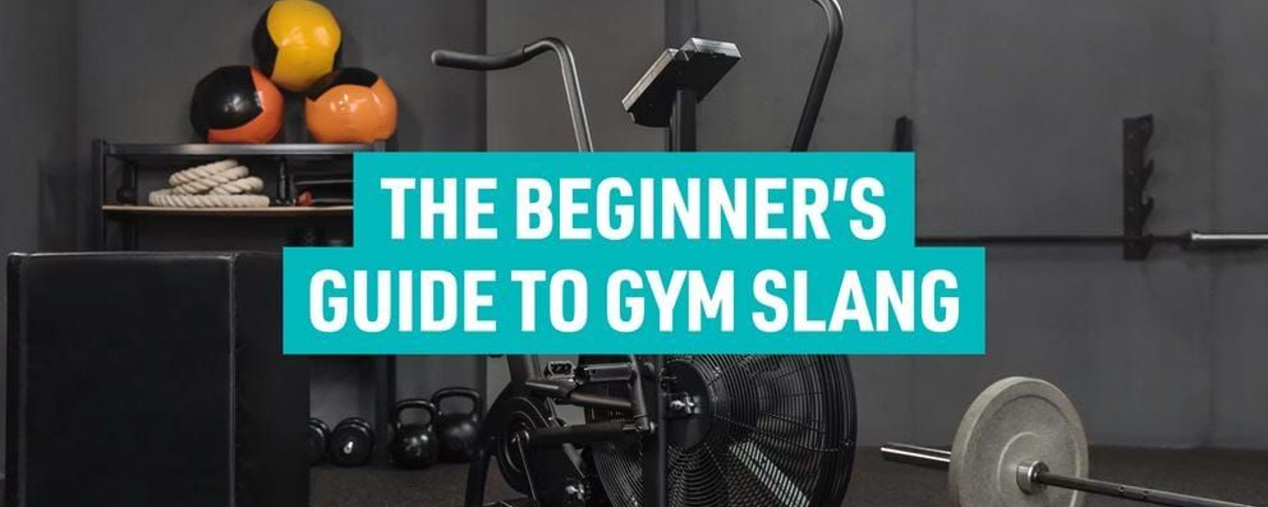Exercise bike, weights, medicine balls, and a plyometric box in a gym room