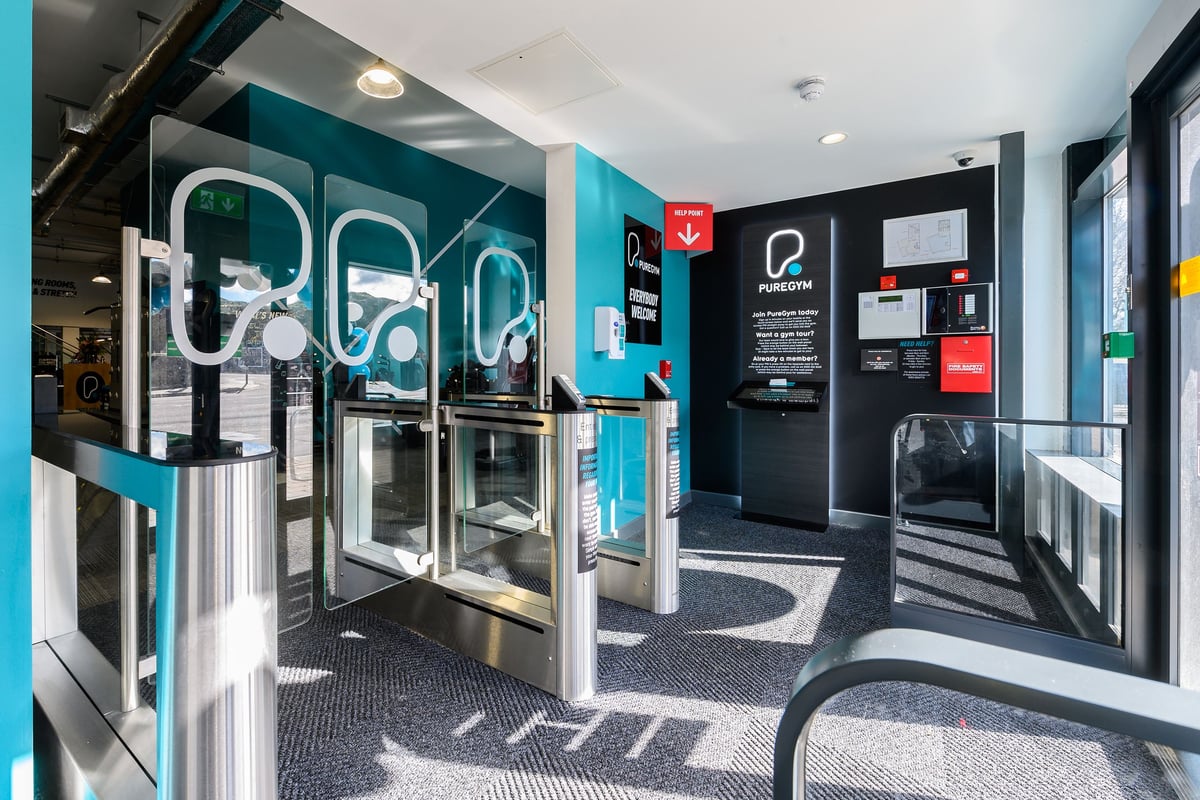 PureGym Bath Spring Wharf: Self-service kiosks for gym members, turquoise branding, and a small reception area.