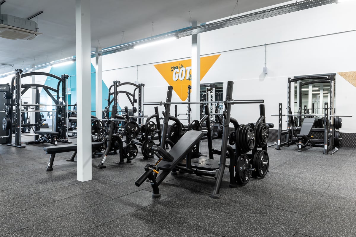 PureGym Peterborough Brotherhood Retail Park: Gym studio with weight racks, benches, free weights, and rubberized flooring.