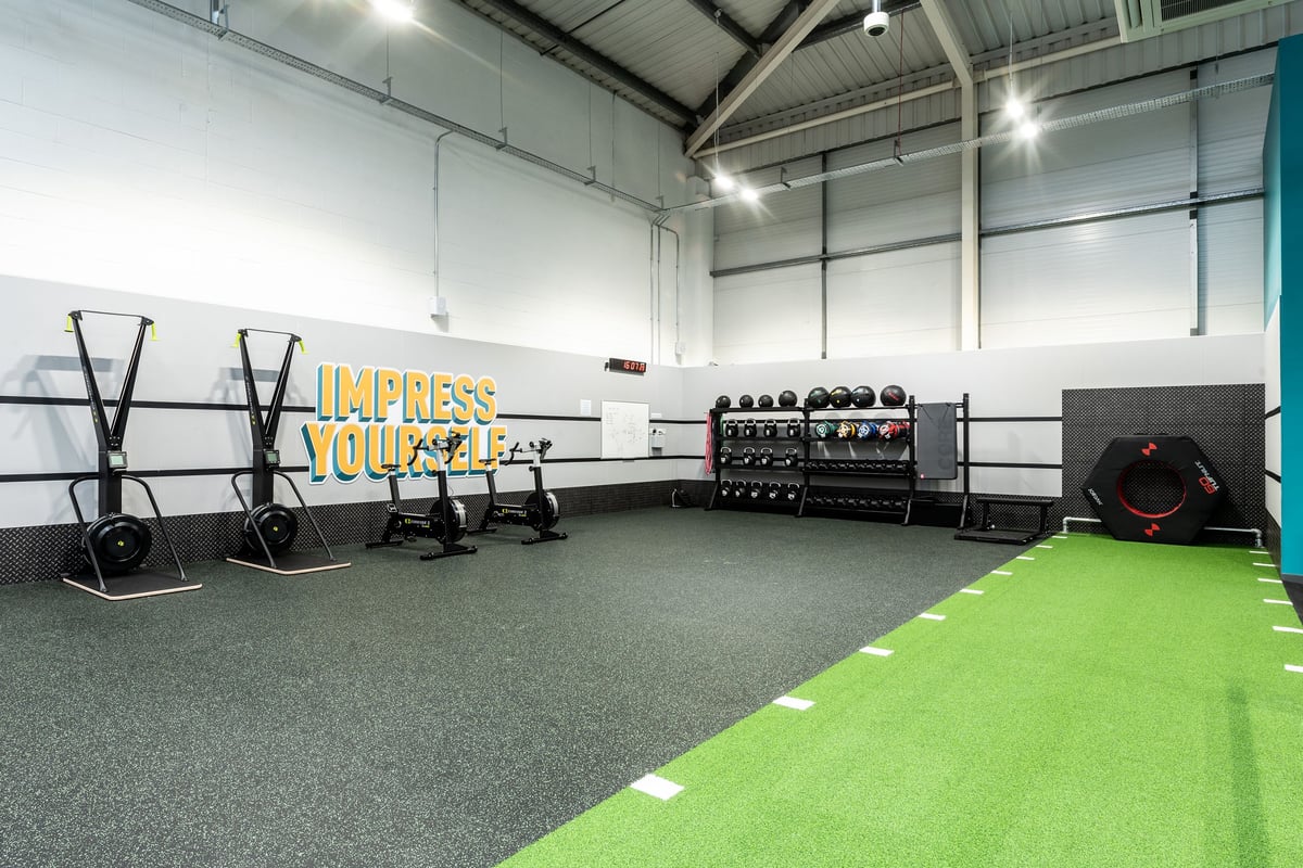 PureGym Newbury: Resistance sleds, racks for weightlifting, dumbbell and barbell weight racks, green turf area.