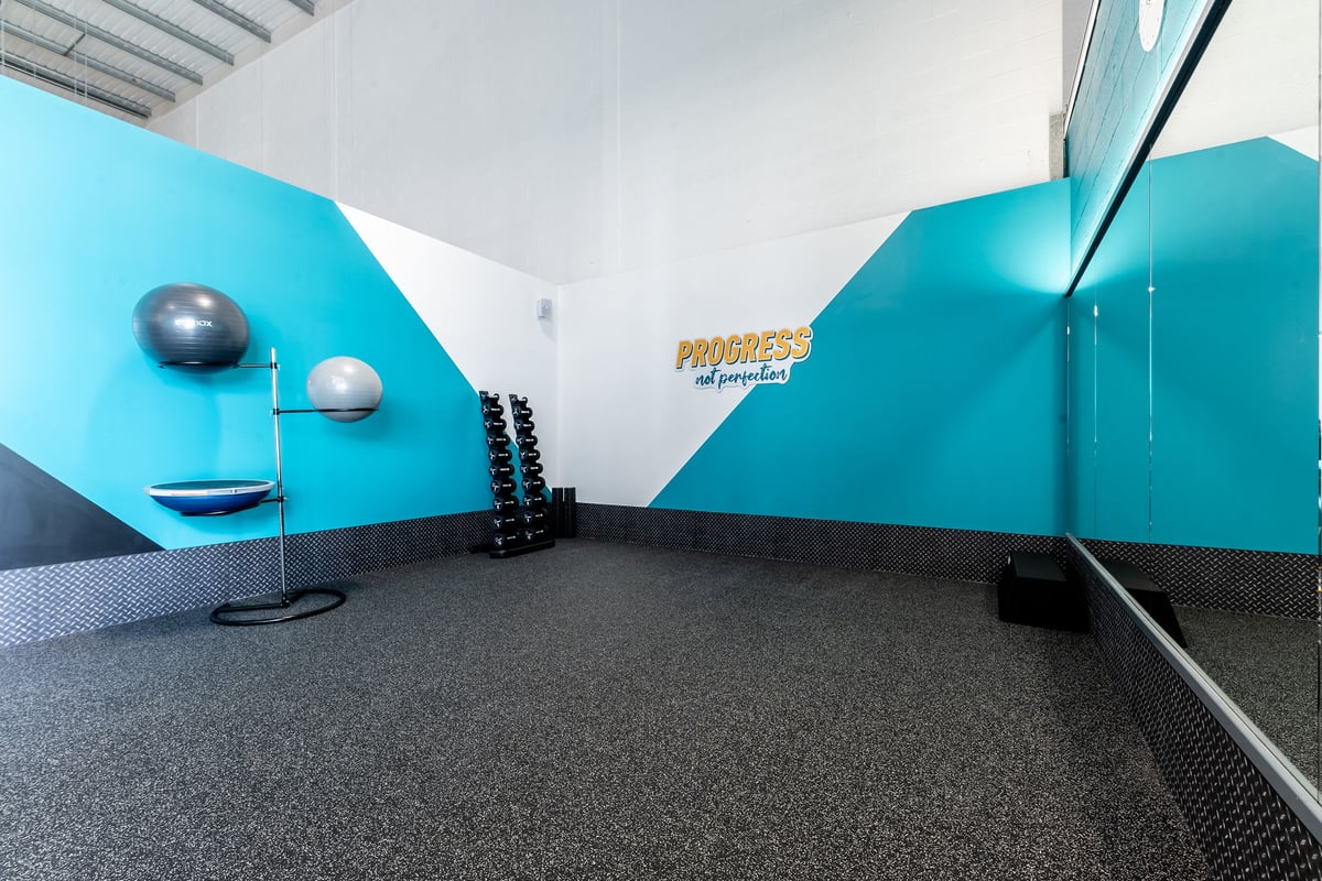 PureGym Durham City Retail Park: Weights, balance balls, mirrored walls in teal and grey colour scheme.